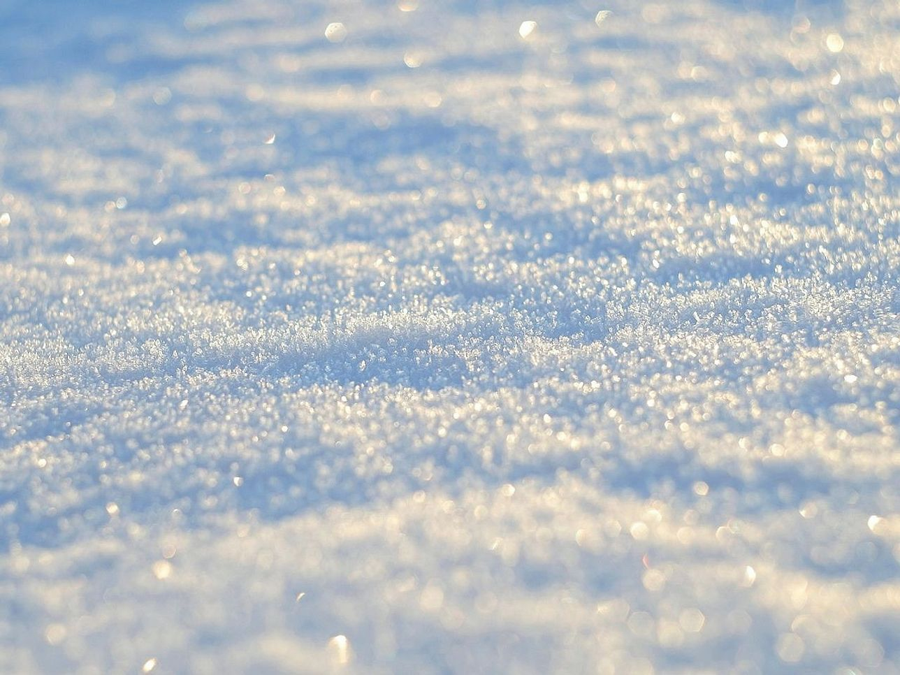 Sunlight glinting off an icy mountain lake surface