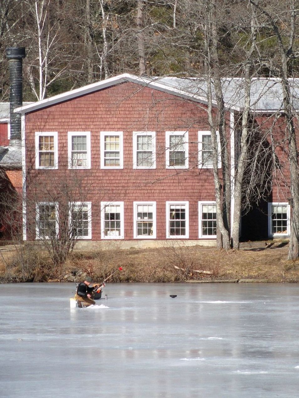 Angler holding a prize fish through the ice hole